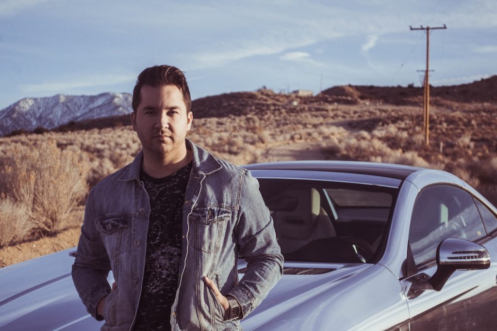 Samochód hybrydowy podłączony do ładowarki na zielonym parkingu